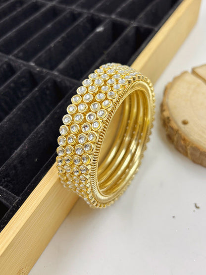 Ishhaara Gold Kundan Bangles - A pair of gold bangles with intricate Kundan work and sparkling stones