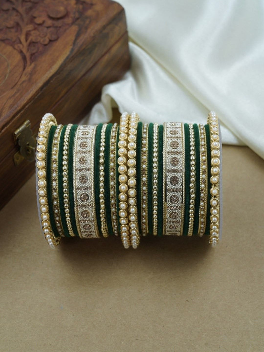 Ishhaara Green and Gold Embellished Bangle Set - a stack of green and gold bangles with pearl and velvet details