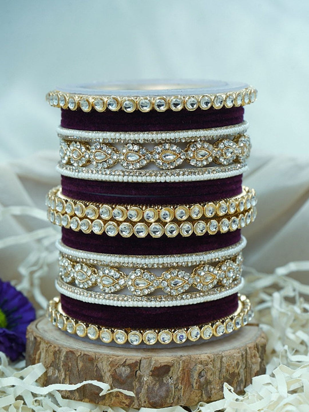 Ishhaara Green Velvet Kundan Bangles Set - a set of green and gold bangles with kundan stones on a wooden stand - view 17