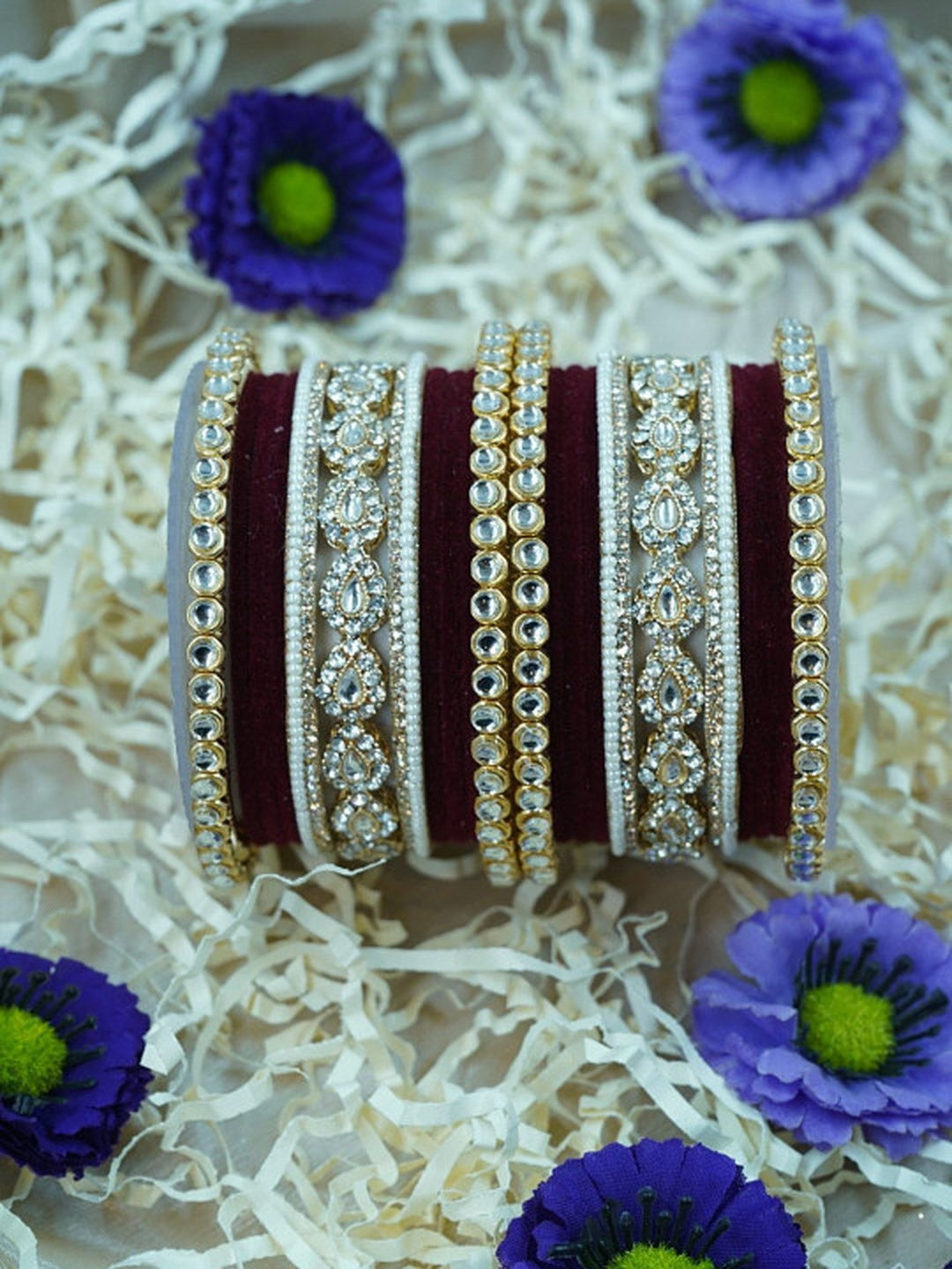 Ishhaara Green Velvet Kundan Bangles Set - a set of green and gold bangles with kundan stones on a wooden stand - view 4