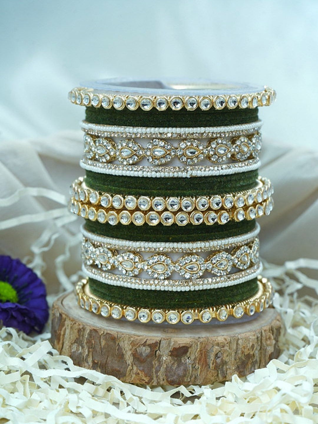 Ishhaara Green Velvet Kundan Bangles Set - a set of green and gold bangles with kundan stones on a wooden stand - view 5