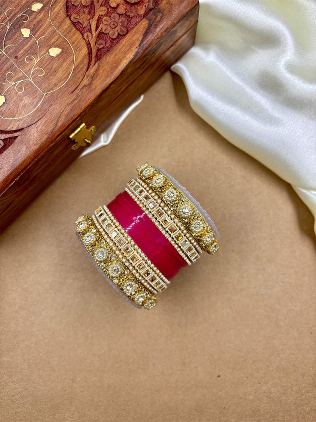 Ishhaara Handcrafted Kundan Bangles Set - a stack of intricately designed bangles with red glass center