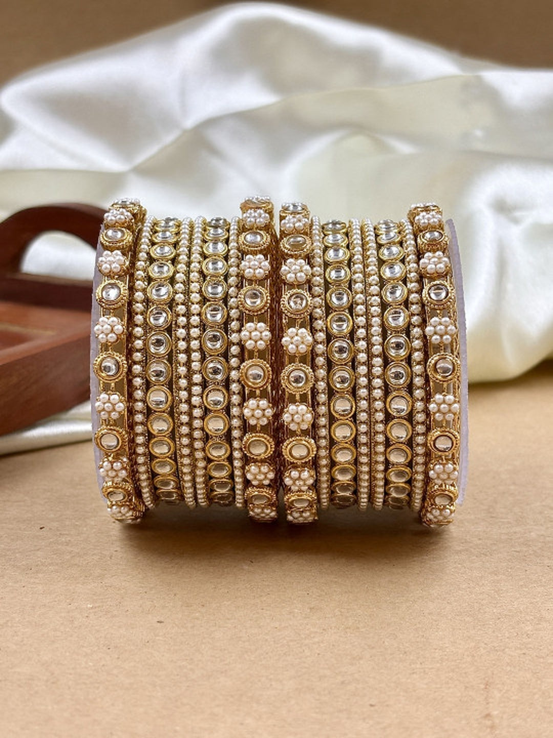 Ishhaara Kundan Bangle Set in Gold - a stack of intricately designed gold bangles with pearls and clear stones