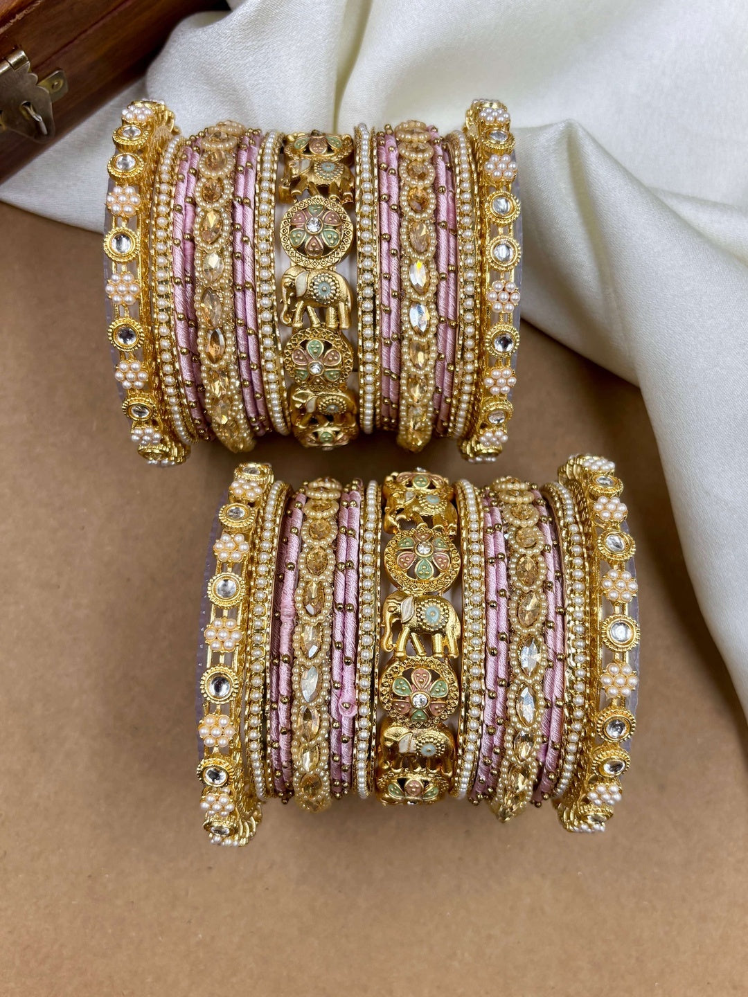 Ishhaara Luxurious Gold Kundan Bangle Set - A pair of intricately designed gold bangles with pink silk thread and rhinestones