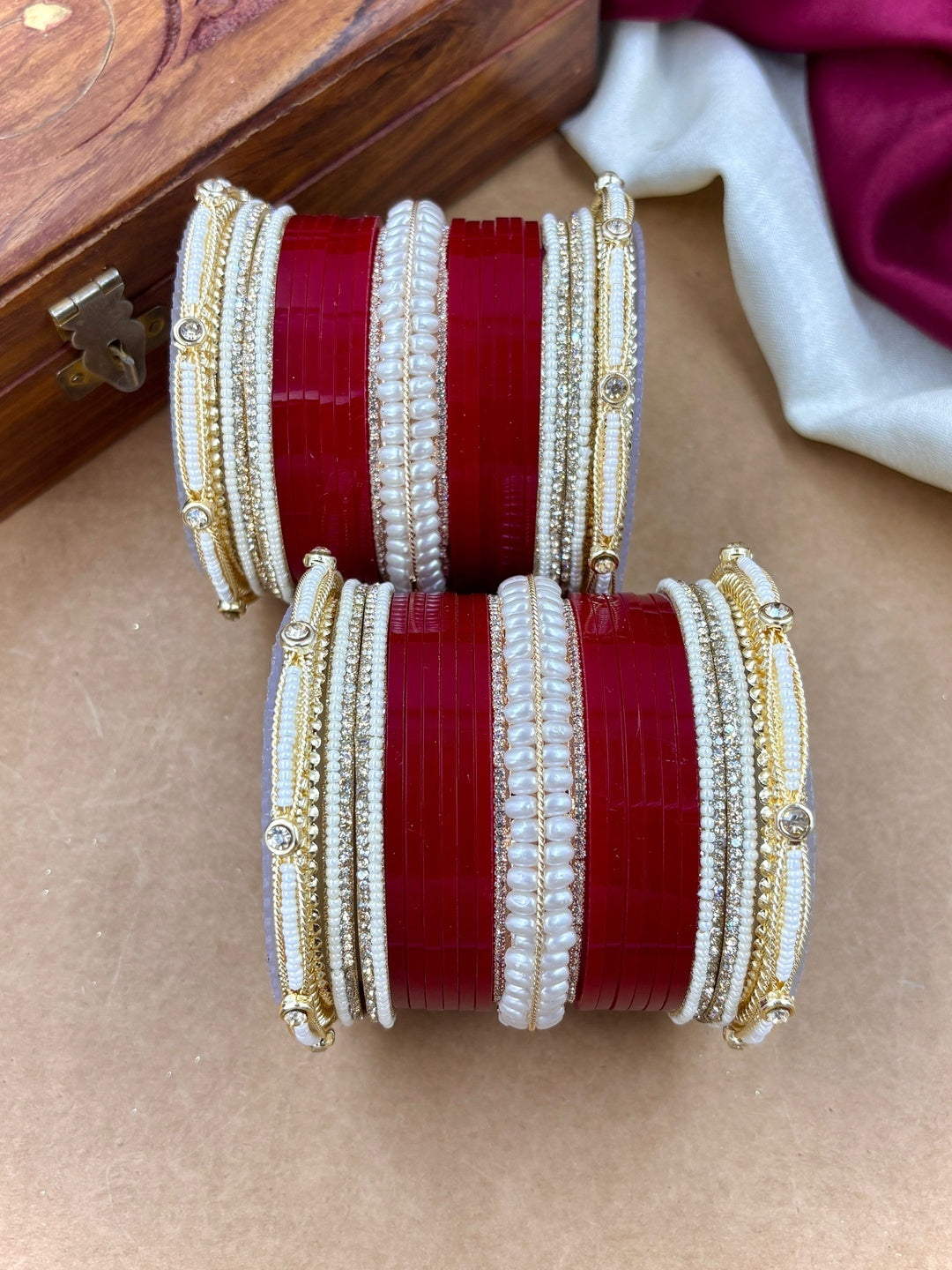 Ishhaara Red and White Bangle Set - A pair of intricately designed red and white bangles with gold accents