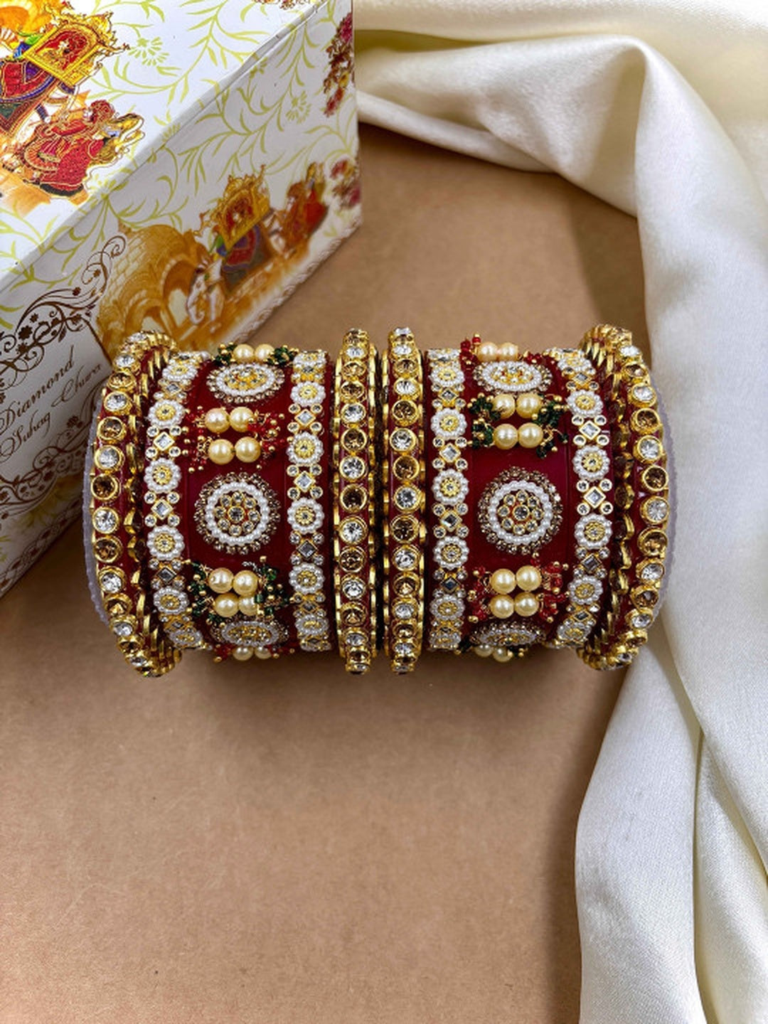 Ishhaara Red Kundan Bangle Set - a stack of intricately designed red and gold bangles
