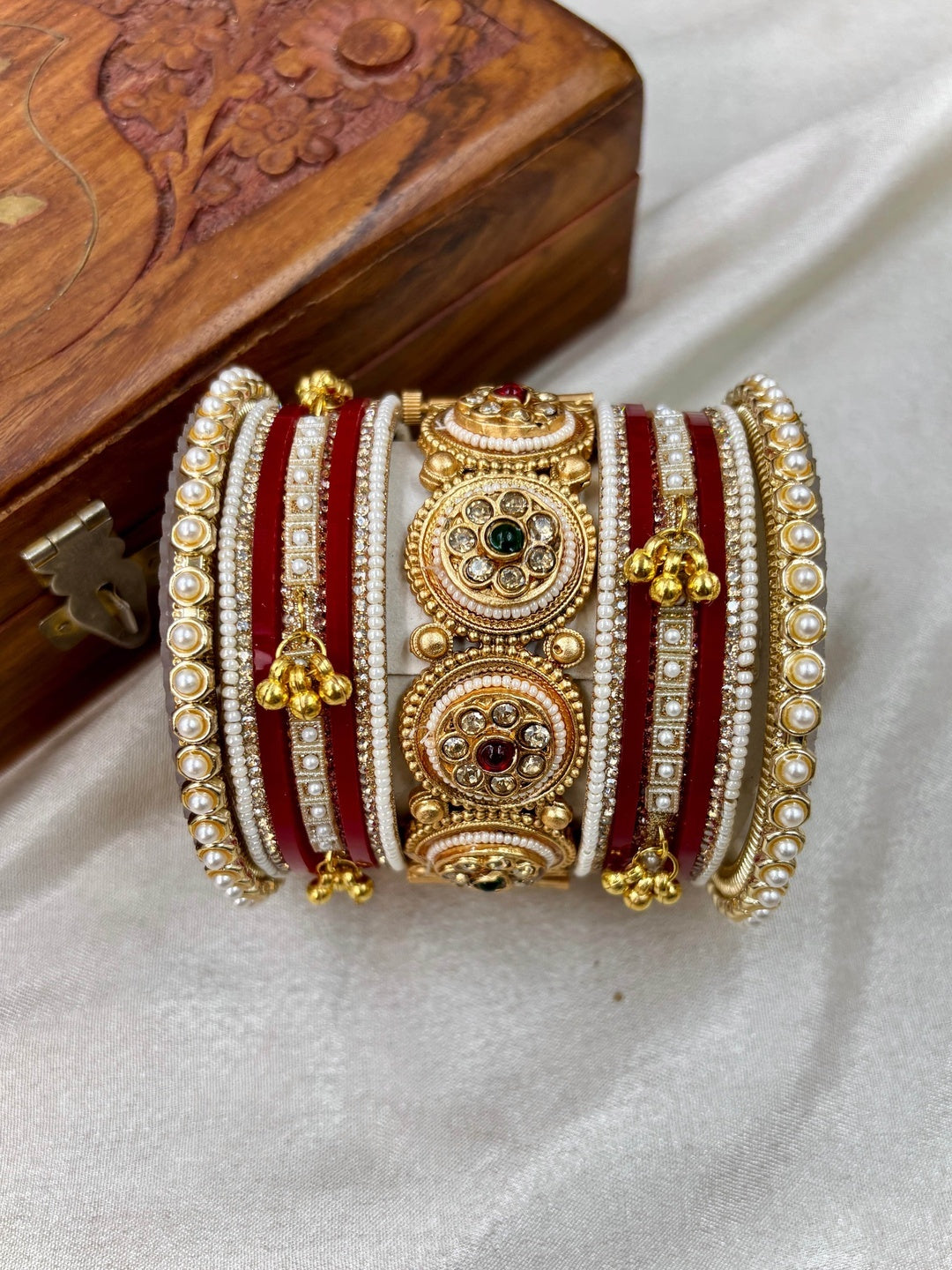 Ishhaara Traditional Kundan Bangle Bracelet Set - Close-up of a woman's hands adorned with red and gold bangles - view 6